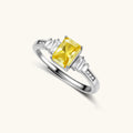 Sterling silver ring with emerald-cut yellow moissanite center stone and clear baguette side stones in elegant setting
