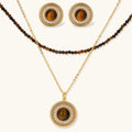 Gold-plated circular pendant necklace and matching earrings with natural stone centers and ornate rope detailing