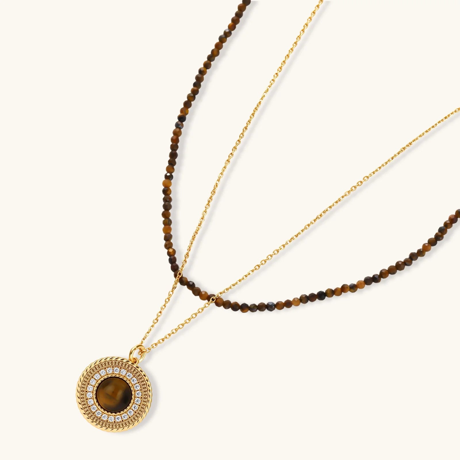 Gold-plated circular pendant necklace and matching earrings with natural stone centers and ornate rope detailing