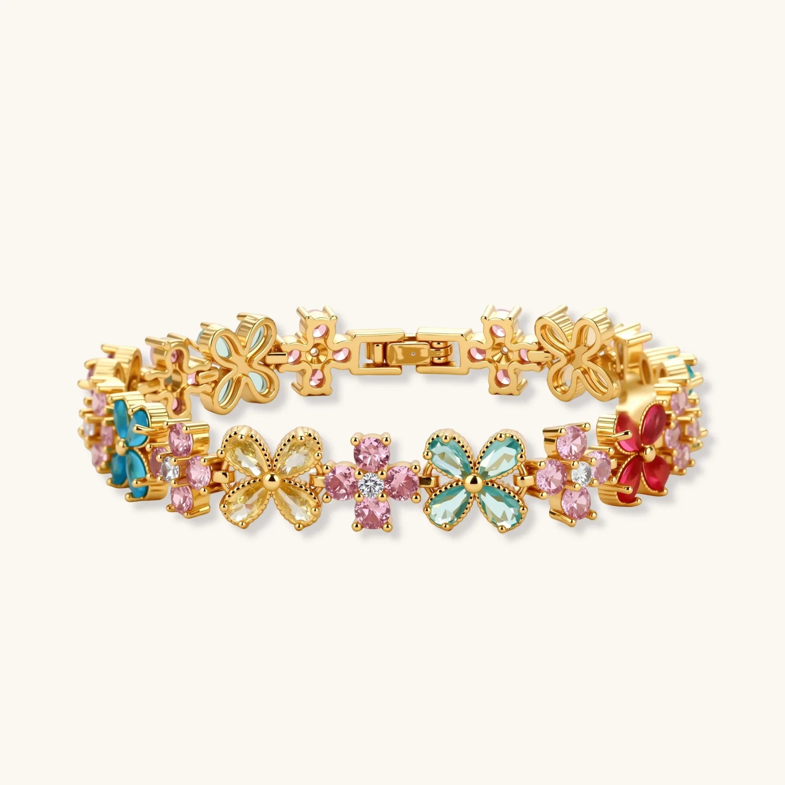 Gold-plated jewelry set with pink, turquoise and red flower-shaped cubic zirconia stones, featuring necklace, earrings and bracelet.