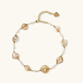 Gold-plated necklace with wire-wrapped shell pieces and freshwater pearls on neutral background, adjustable chain visible.