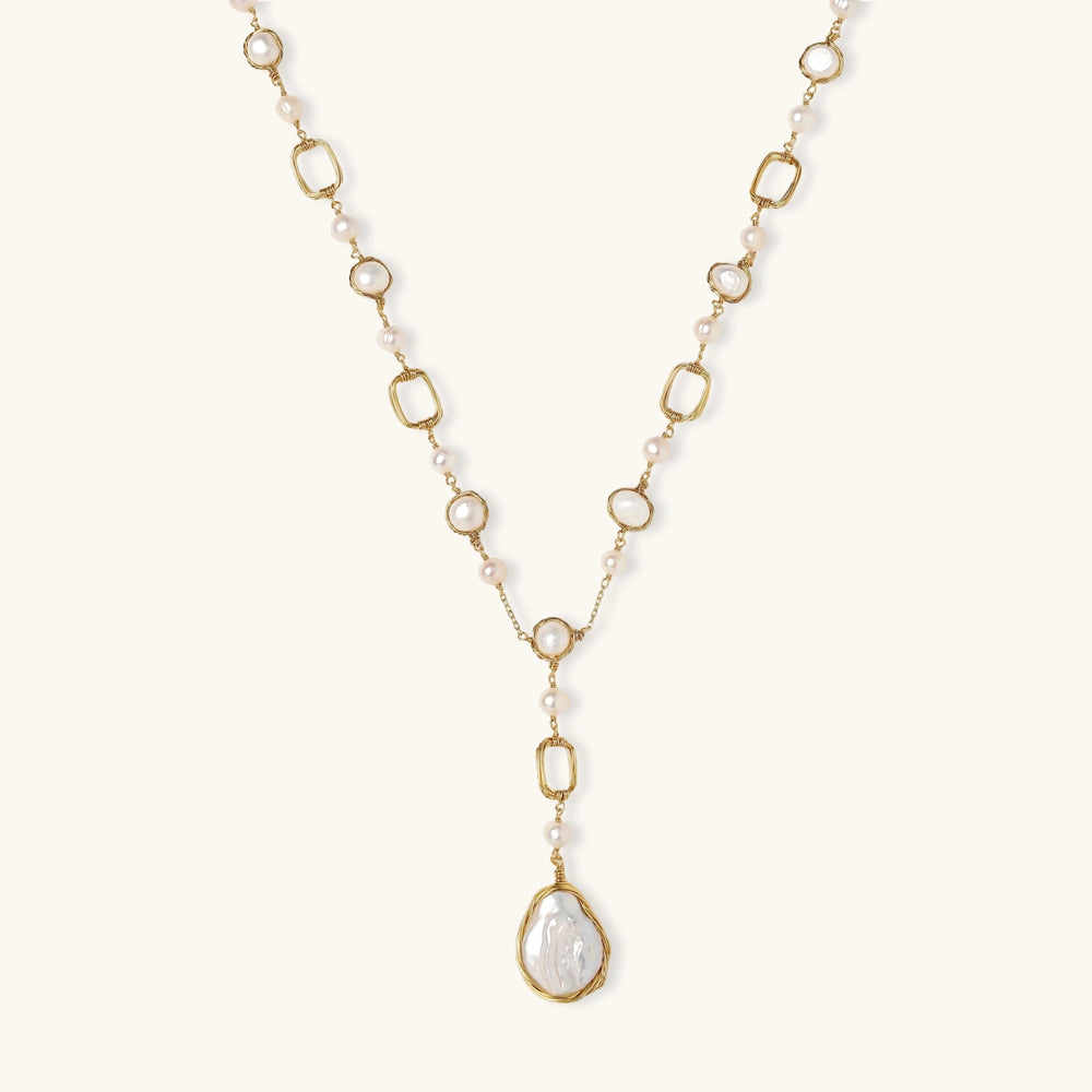 Long gold-plated necklace with alternating freshwater pearls and crystal bezels, featuring a large baroque pearl pendant
