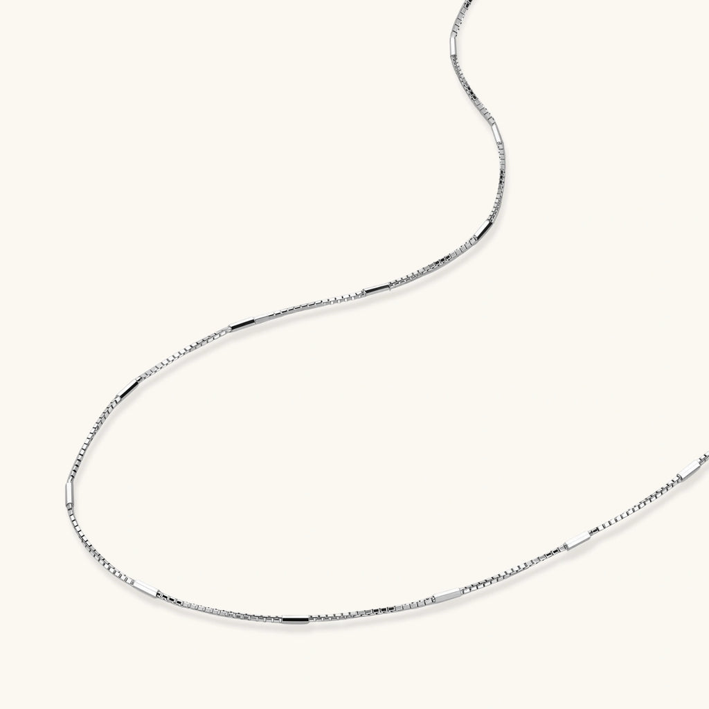 Delicate platinum-plated sterling silver necklace with alternating textured cubic links and smooth chain sections.