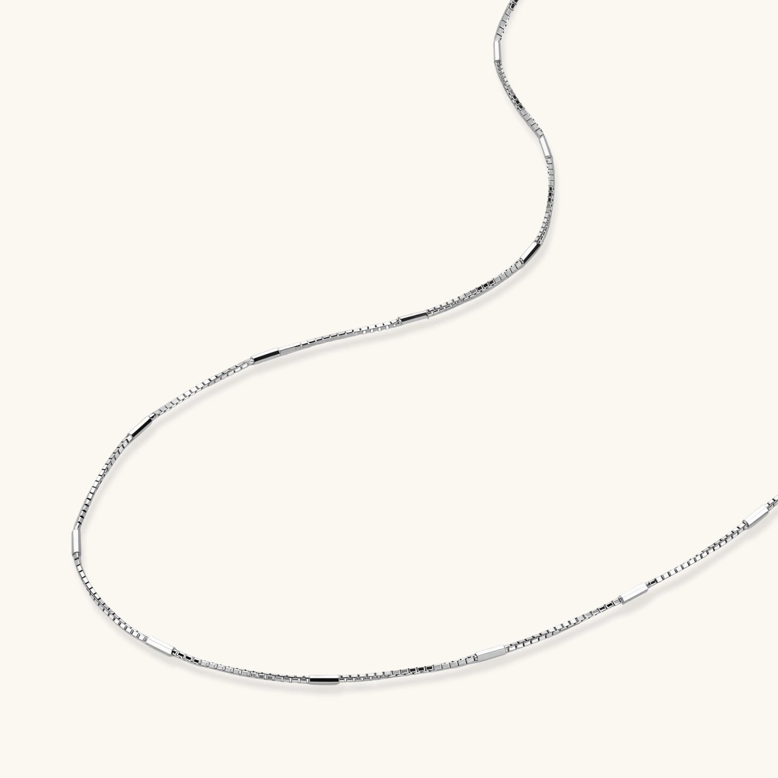 Delicate platinum-plated sterling silver necklace with alternating textured cubic links and smooth chain sections.
