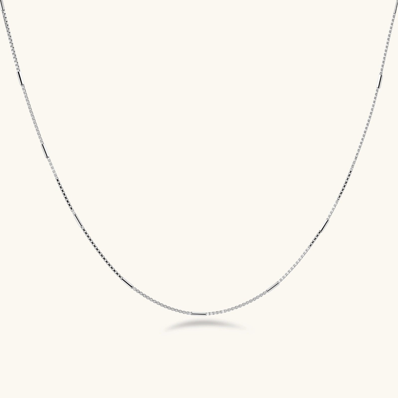 Delicate platinum-plated sterling silver necklace with alternating textured cubic links and smooth chain sections.