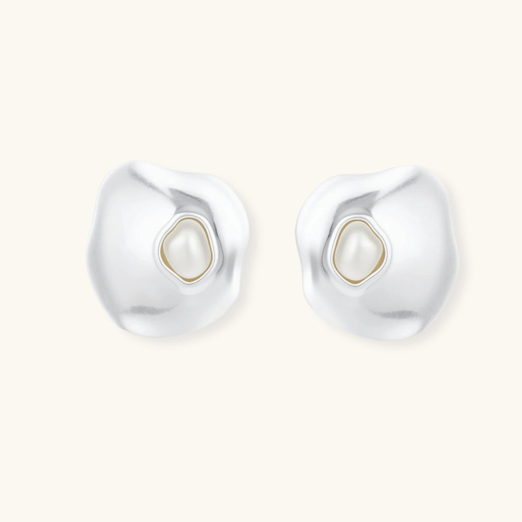 Organic silver stud earrings with white resin pearl centers in fluid stone-like shapes on light background.