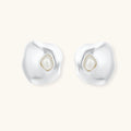 Organic silver stud earrings with white resin pearl centers in fluid stone-like shapes on light background.