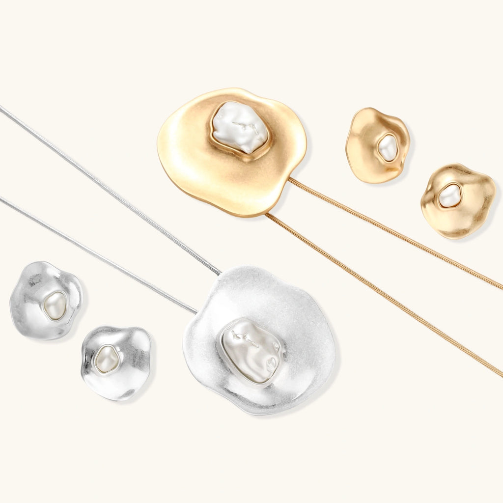 Organic silver stud earrings with white resin pearl centers in fluid stone-like shapes on light background.