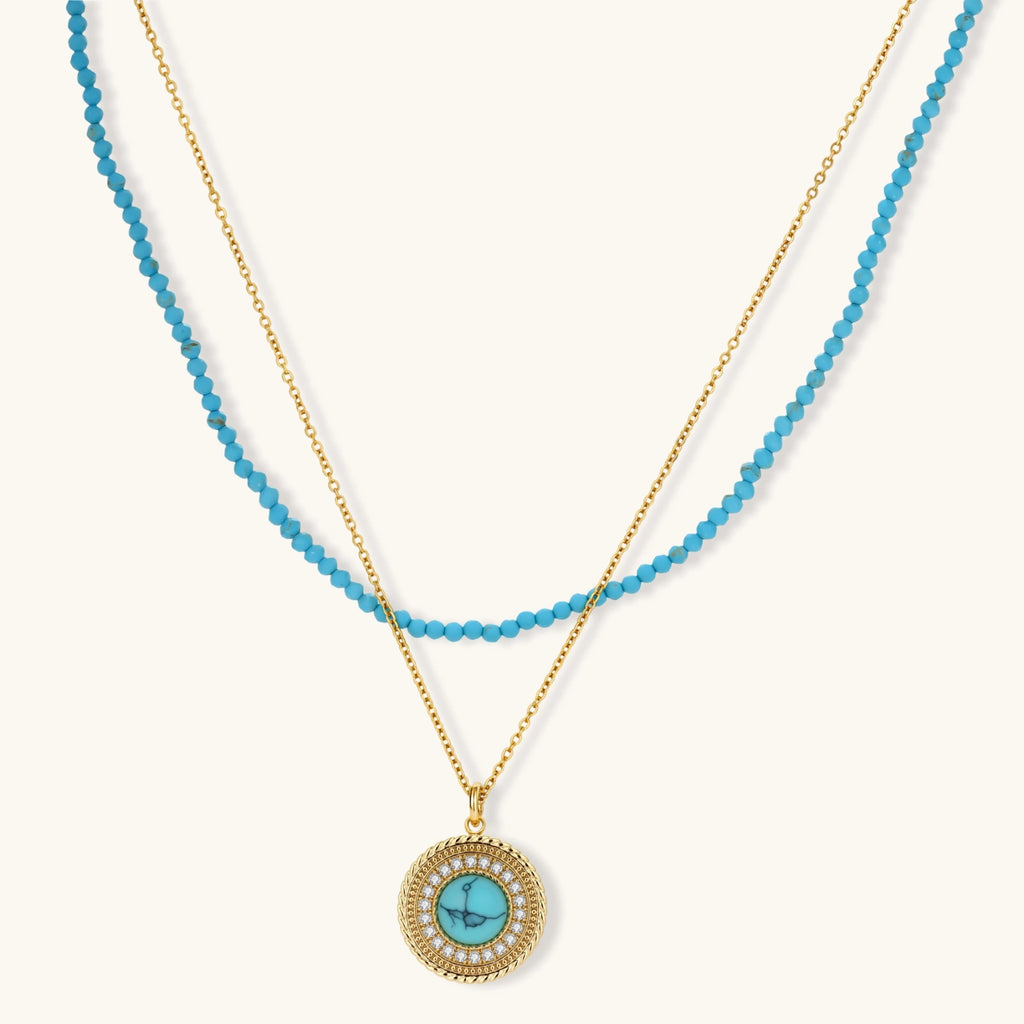 Gold-plated turquoise jewelry set with circular medallion pendant, beaded necklace, and matching stud earrings on white background