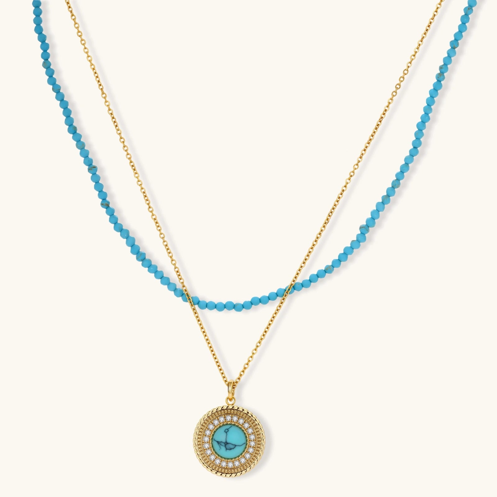 Gold-plated turquoise jewelry set with circular medallion pendant, beaded necklace, and matching stud earrings on white background