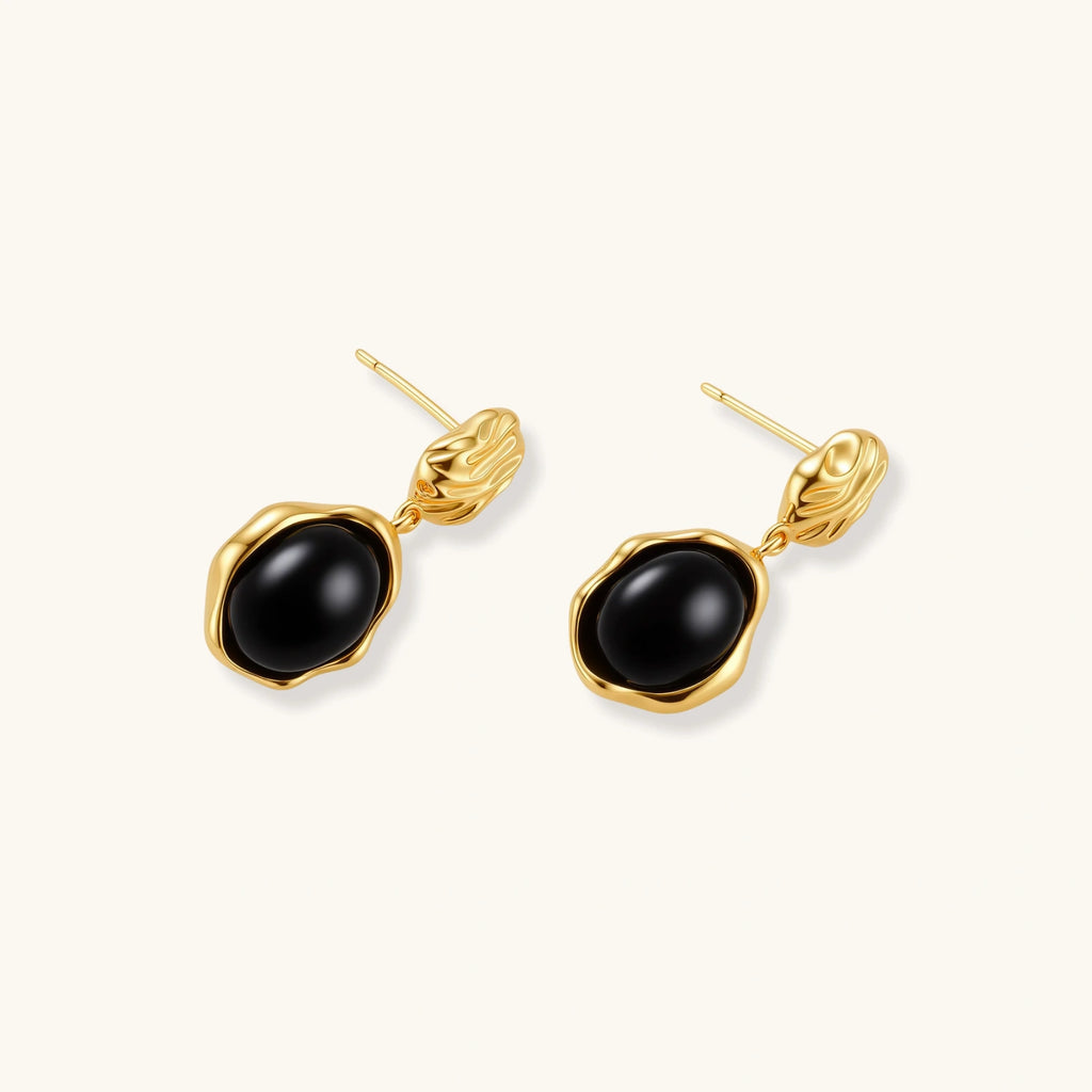 Gold-plated rippled stud earrings with black agate stone drops on white background