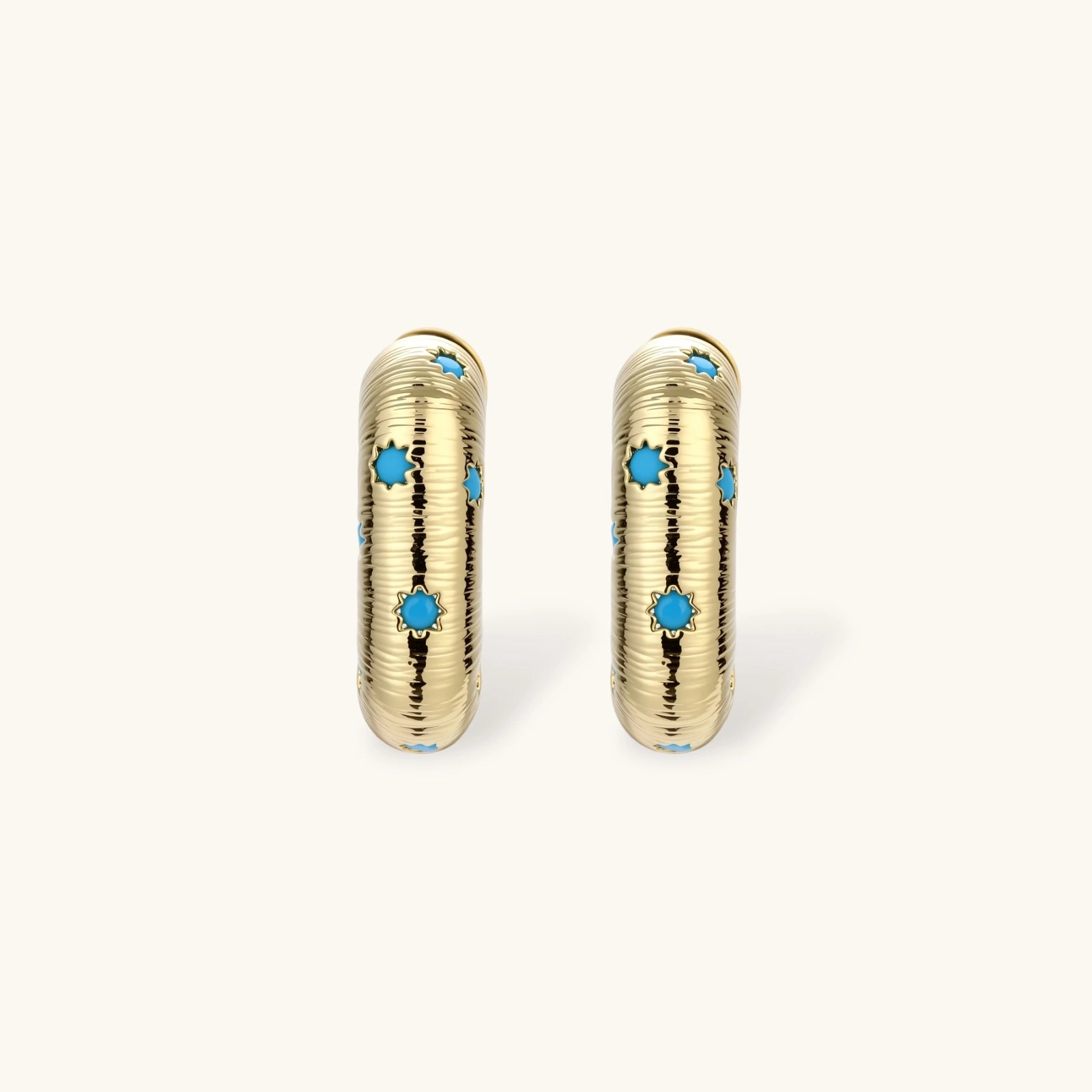 Gold-plated huggie hoop earrings with blue star inlays and textured surface, shown against white background.