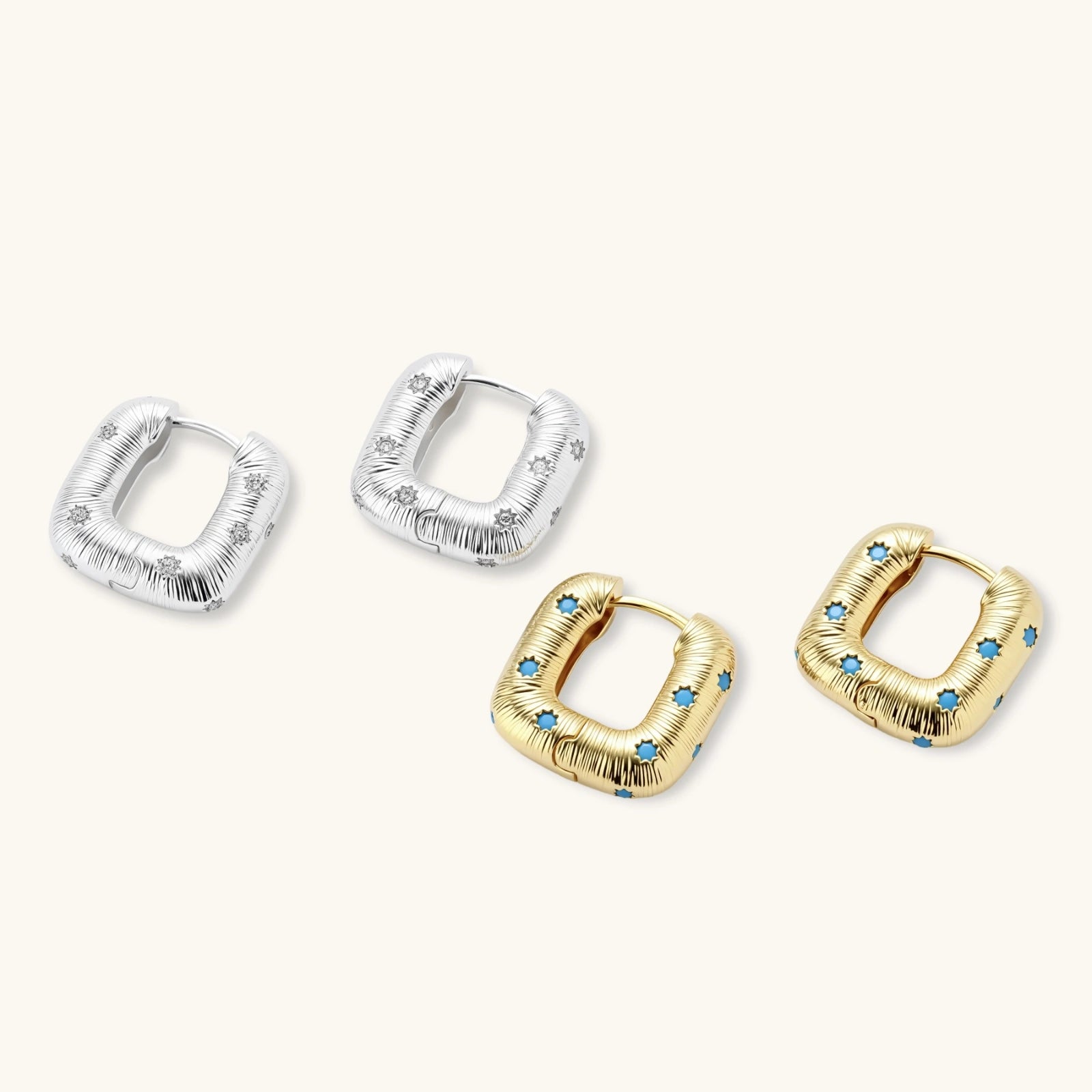 Gold-plated huggie hoop earrings with blue star inlays and textured surface, shown against white background.