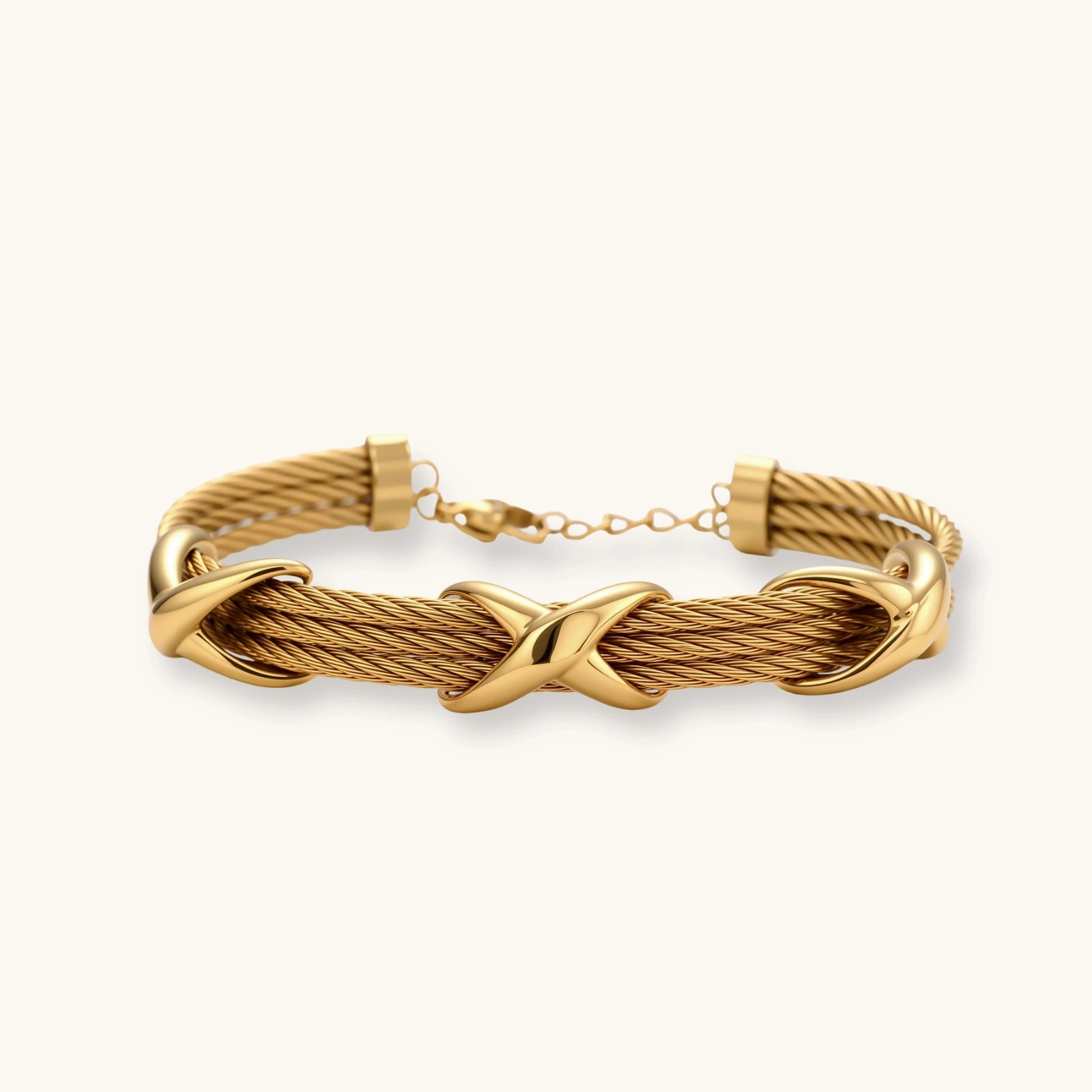 Gold-tone multi-strand twisted cable bracelet with polished X-cross knot accents and adjustable lobster clasp chain.