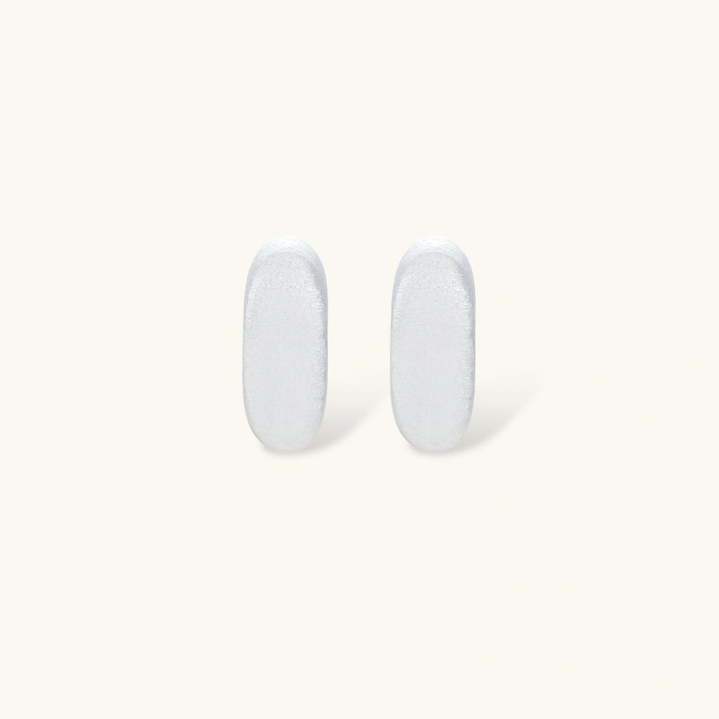 Pair of small silver-plated huggie hoop earrings with clean minimal design on neutral background.