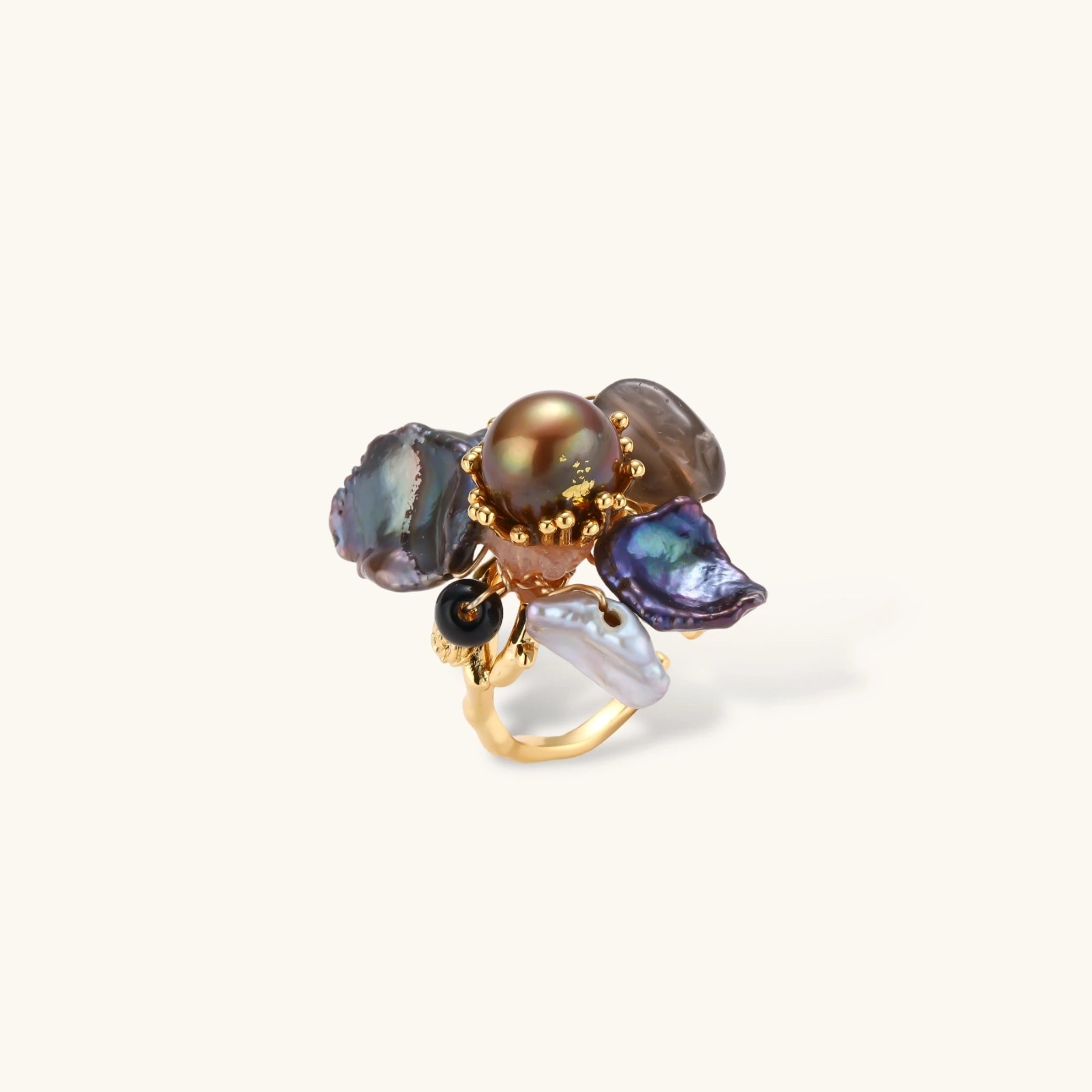 Adjustable gold-plated ring featuring clustered dark baroque pearls in organic arrangement on white background.