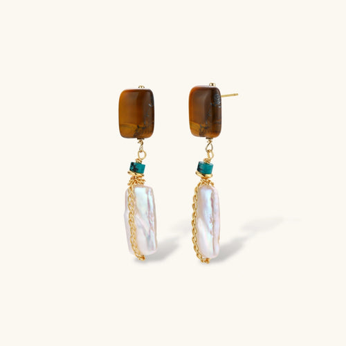 Gold-plated drop earrings with amber stones, teal beads, and wire-wrapped baroque pearls on cream background.