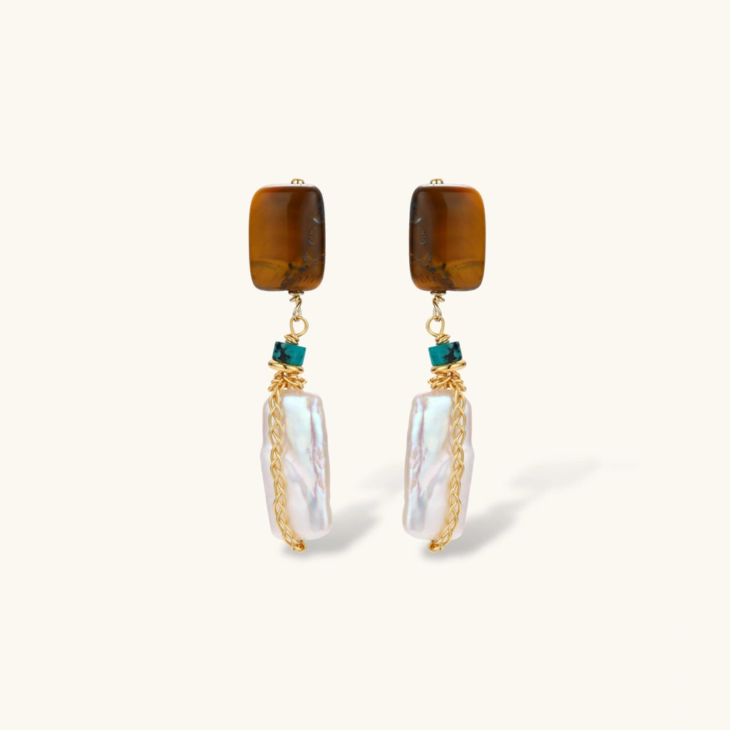 Gold-plated drop earrings with amber stones, teal beads, and wire-wrapped baroque pearls on cream background.