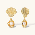 Gold shell-shaped drop earrings with scallop tops and oyster bottoms featuring round freshwater pearls on white background.